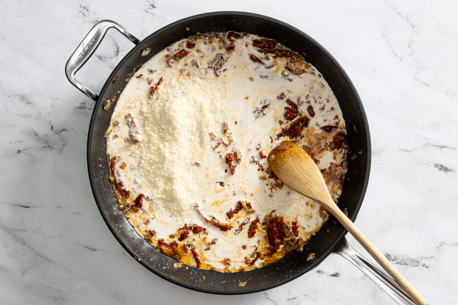 cream and parmesan added to pan for creamy tuscan chicken recipe