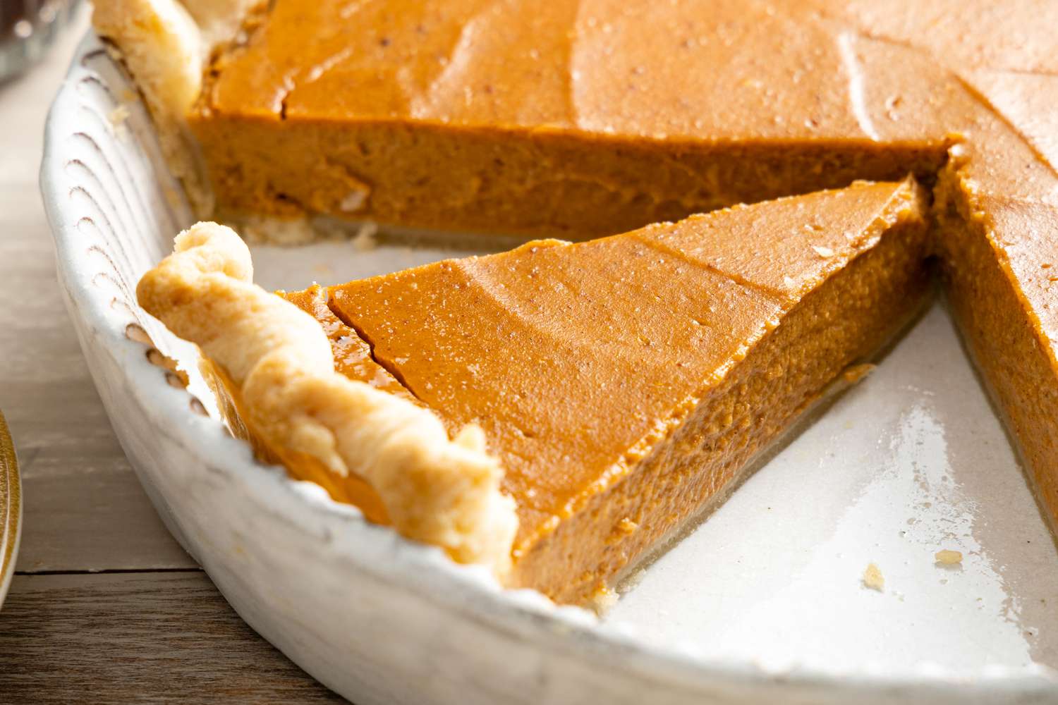 Vegan Pumpkin Pie in a Pie Dish with a Slice of Pie Cut Out