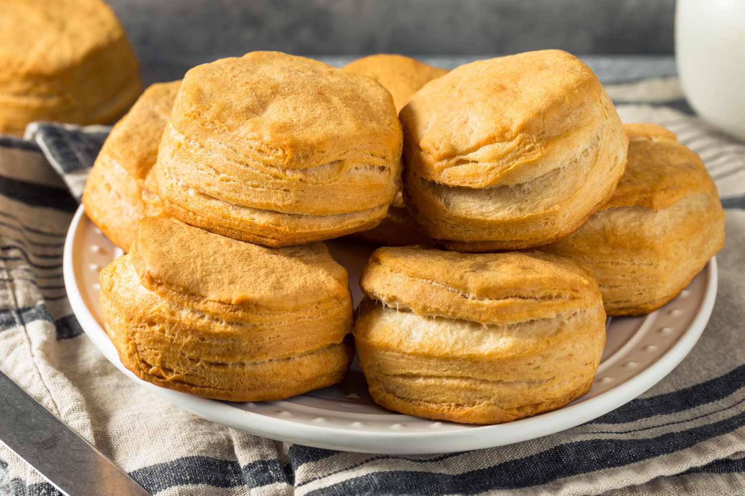 A white plate with buttermilk biscuits stacked high