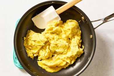 Scrambled eggs in a frying pan with a spatula
