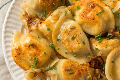Plate of cooked pierogies topped with chopped chives