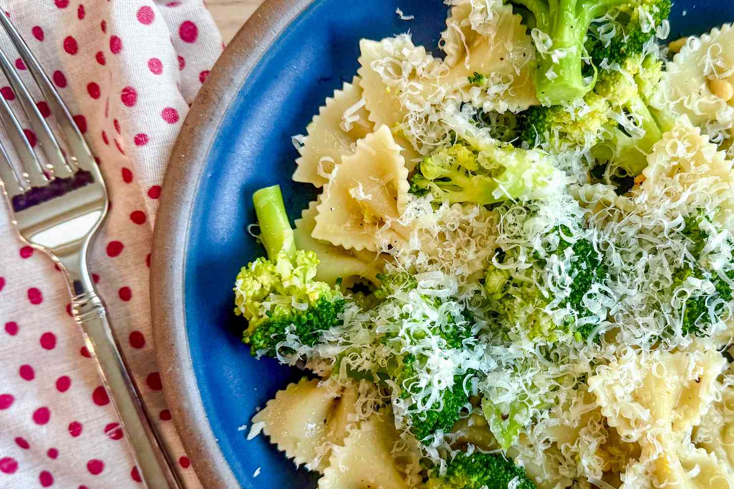 Overhead closeup shot of a blue plate with Ina Garten's broccoli and bowtie pasta recipe