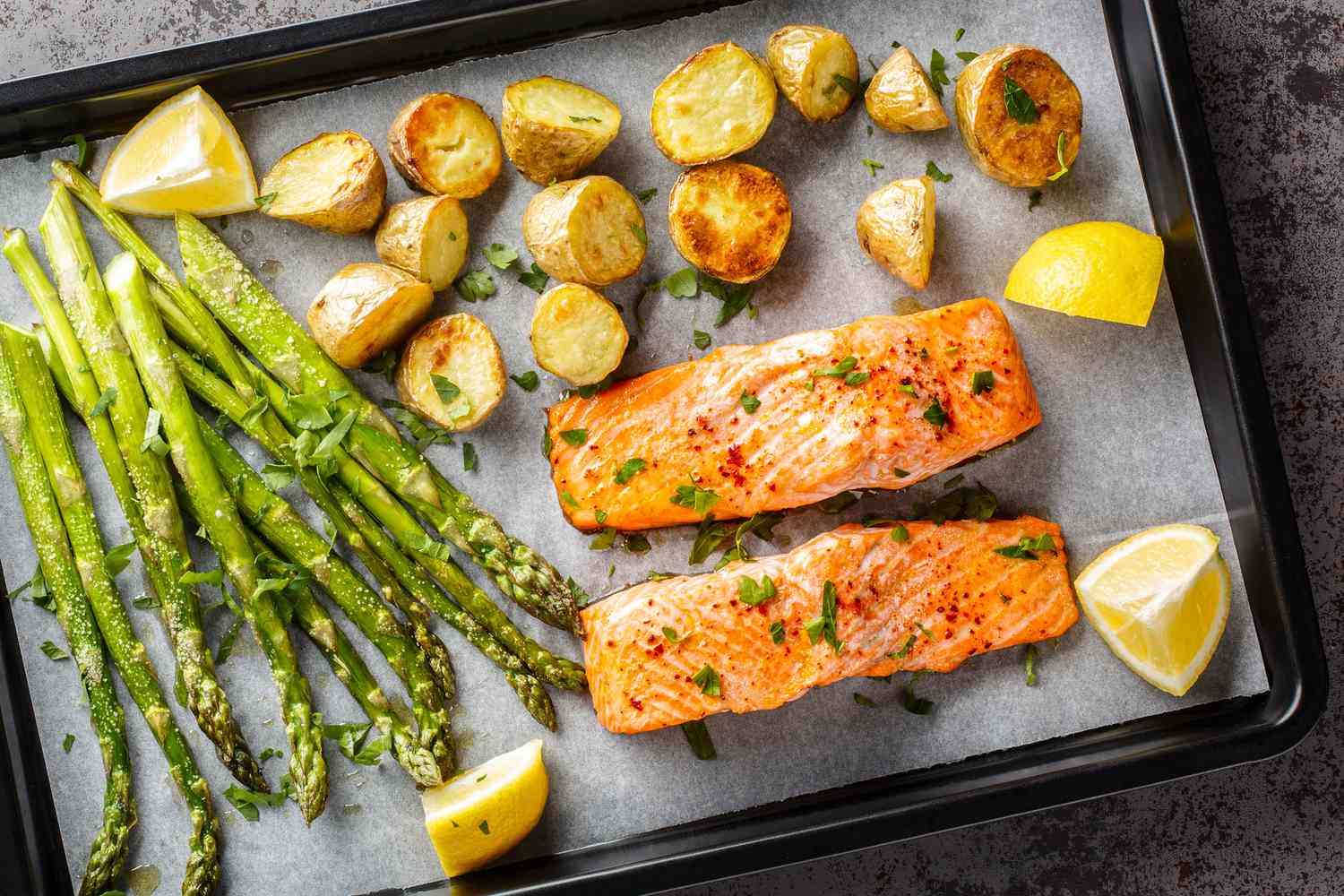 sheet pan with salmon fillets, potatoes, and asparagus
