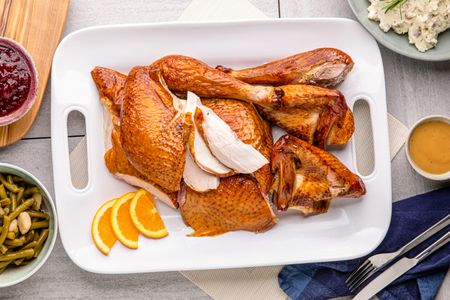 Citrus-brined smoked turkey carved on a platter.