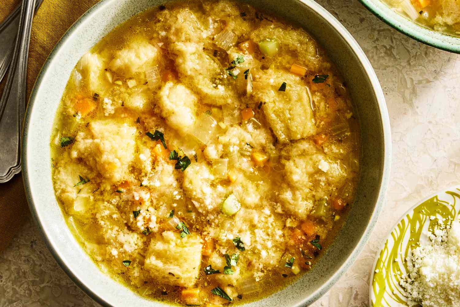 A bowl of pancotto soup with bread chunks and garnished herbs