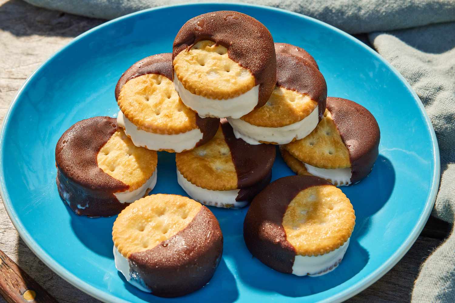 A plate of Ritz cracker ice cream sandwiches partially dipped in chocolate