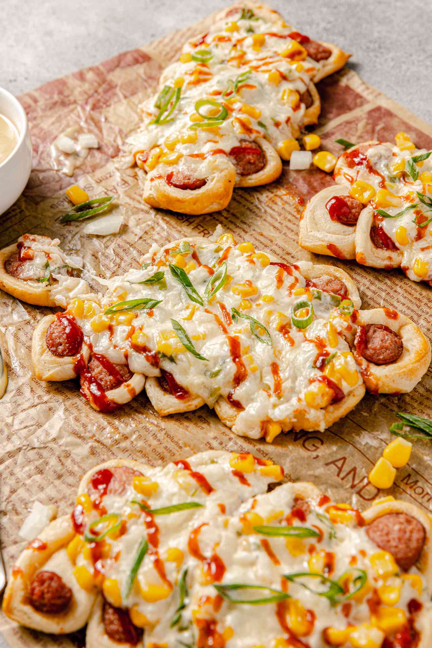 Pull-Apart Corn Cheese Pigs in a Blanket with a Piece Pulled Off Surrounded by More 