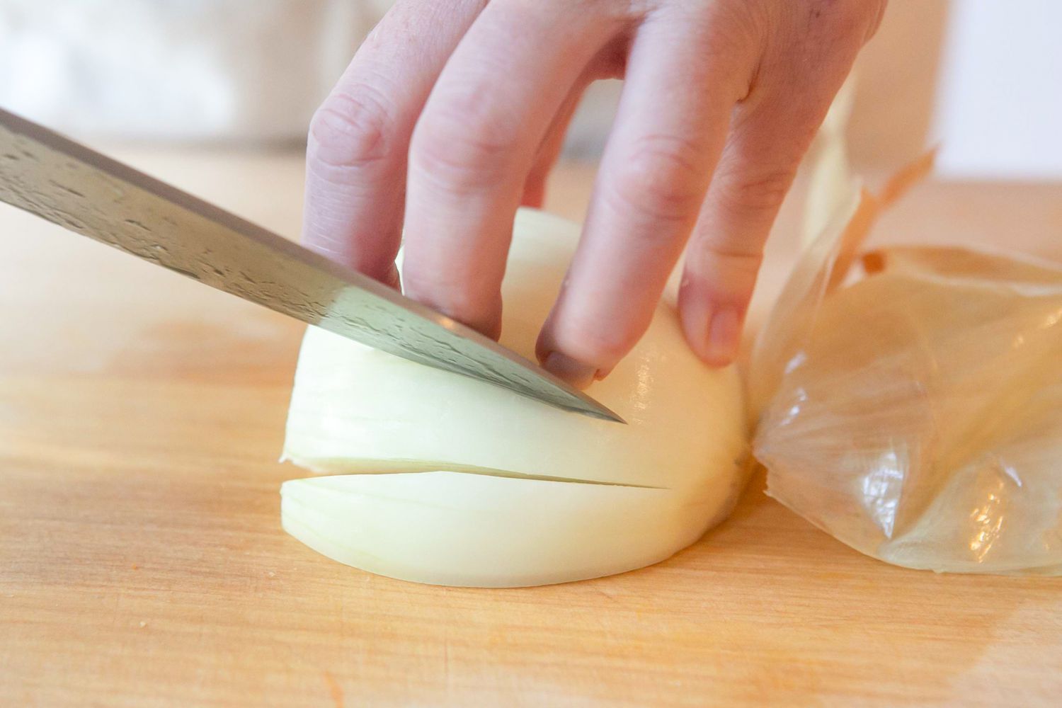 Using the Knife Tip, With the Onion on the Counter, the Onion Is Cut Length Wise at an Angle 