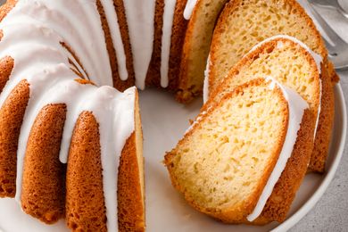 Bundt cake with icing and slices showing the interior texture served on a plate