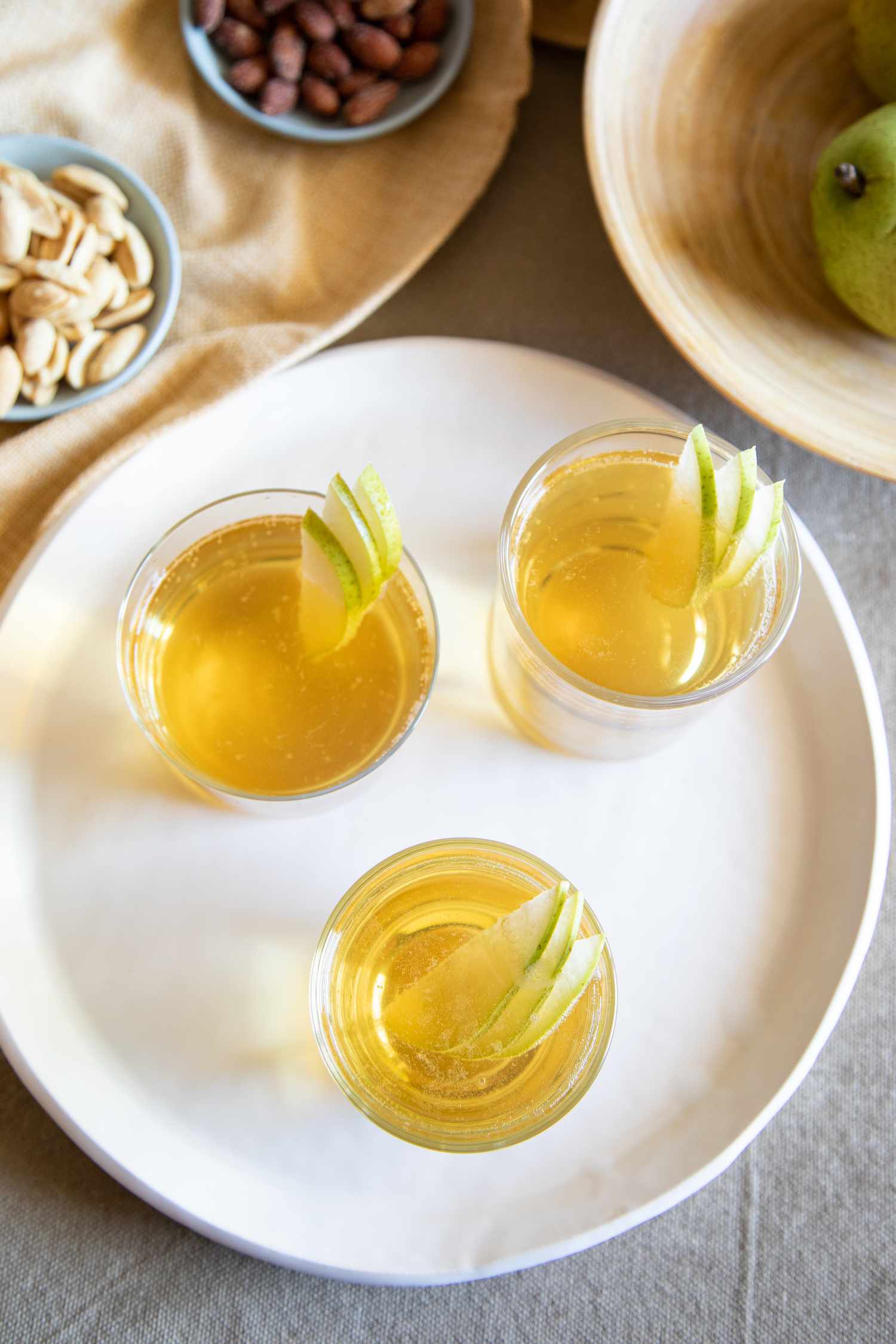 Overhead view of spiced pear punch in glasses on a tray.