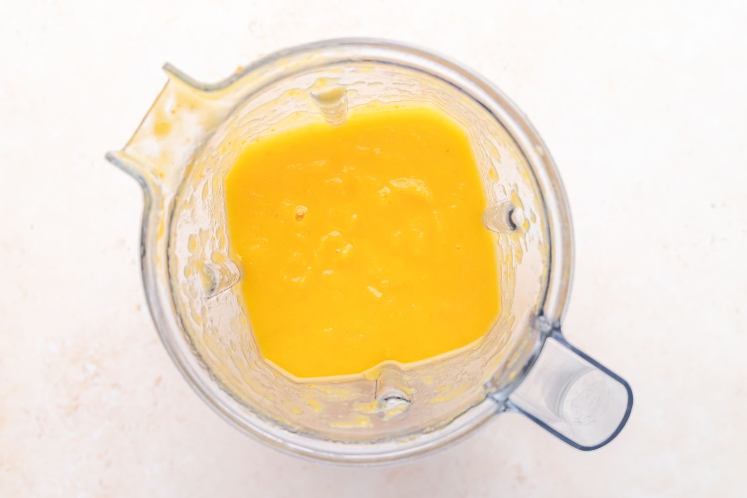 Pureed butternut squash soup in a blender.