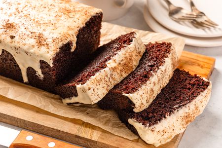 Chocolate stout loaf cake on a wooden board, with a few slices cut