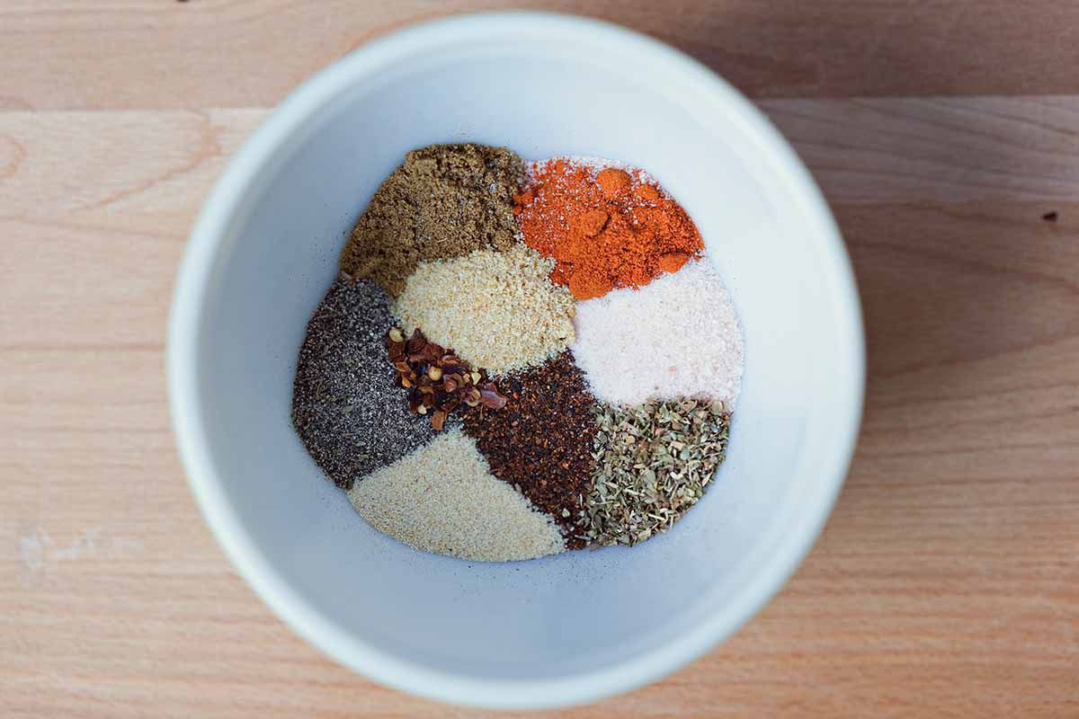 Taco Pasta Skillet Recipe combine spices and herbs in a white bowl for seasoning mix