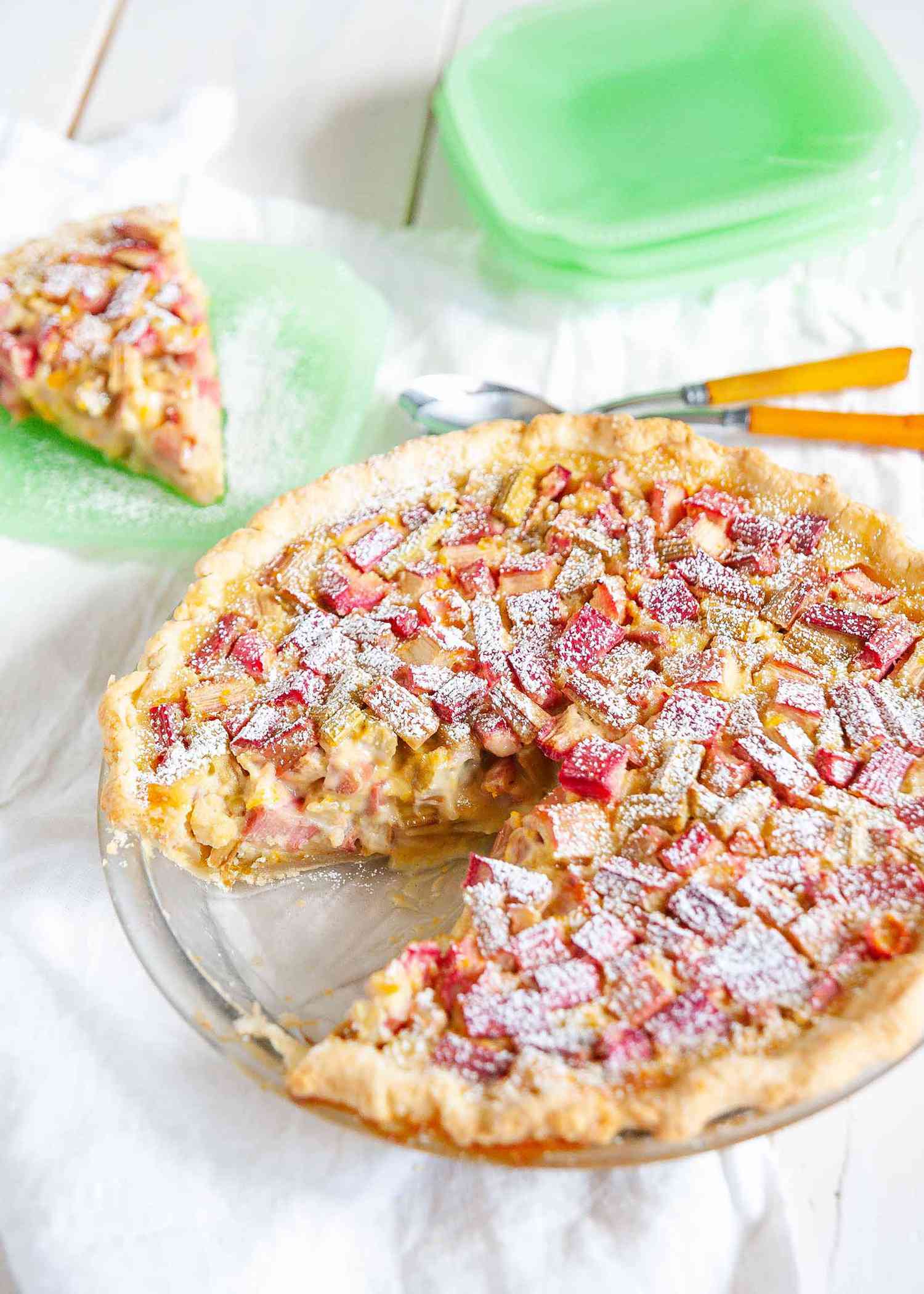 Best Rhubarb Pie Recipe - rhubarb pie with powdered sugar on top and a piece is missing