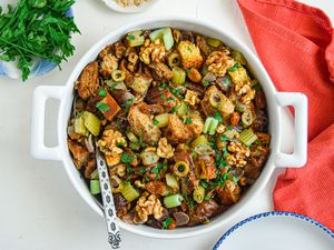 Overhead view of a dutch oven with turkey dressing inside and a red linen next to it.