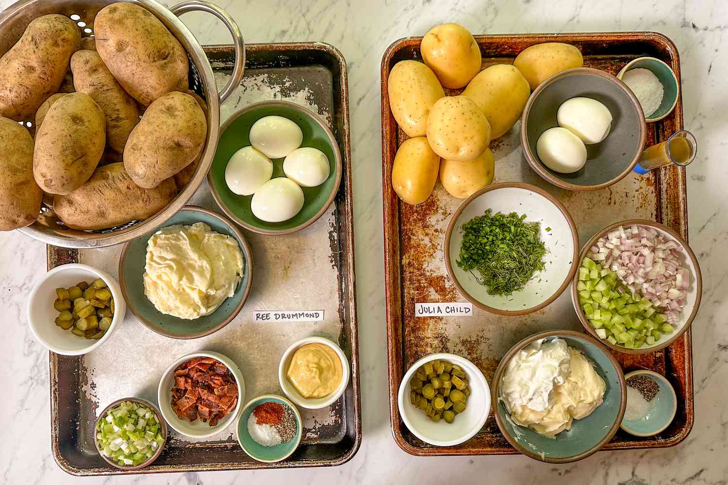 Ingredients for two types of potato salad presented in trays, labeled for comparison and showcasing the required items for each recipe