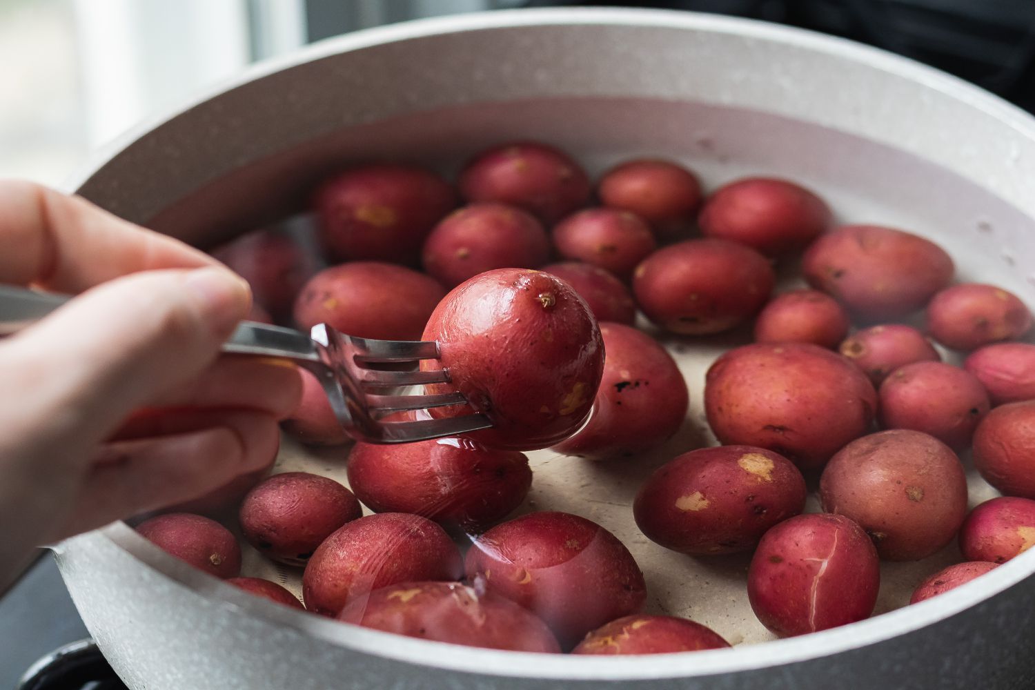 Boiling red potatoes to make a tuna nicoise.