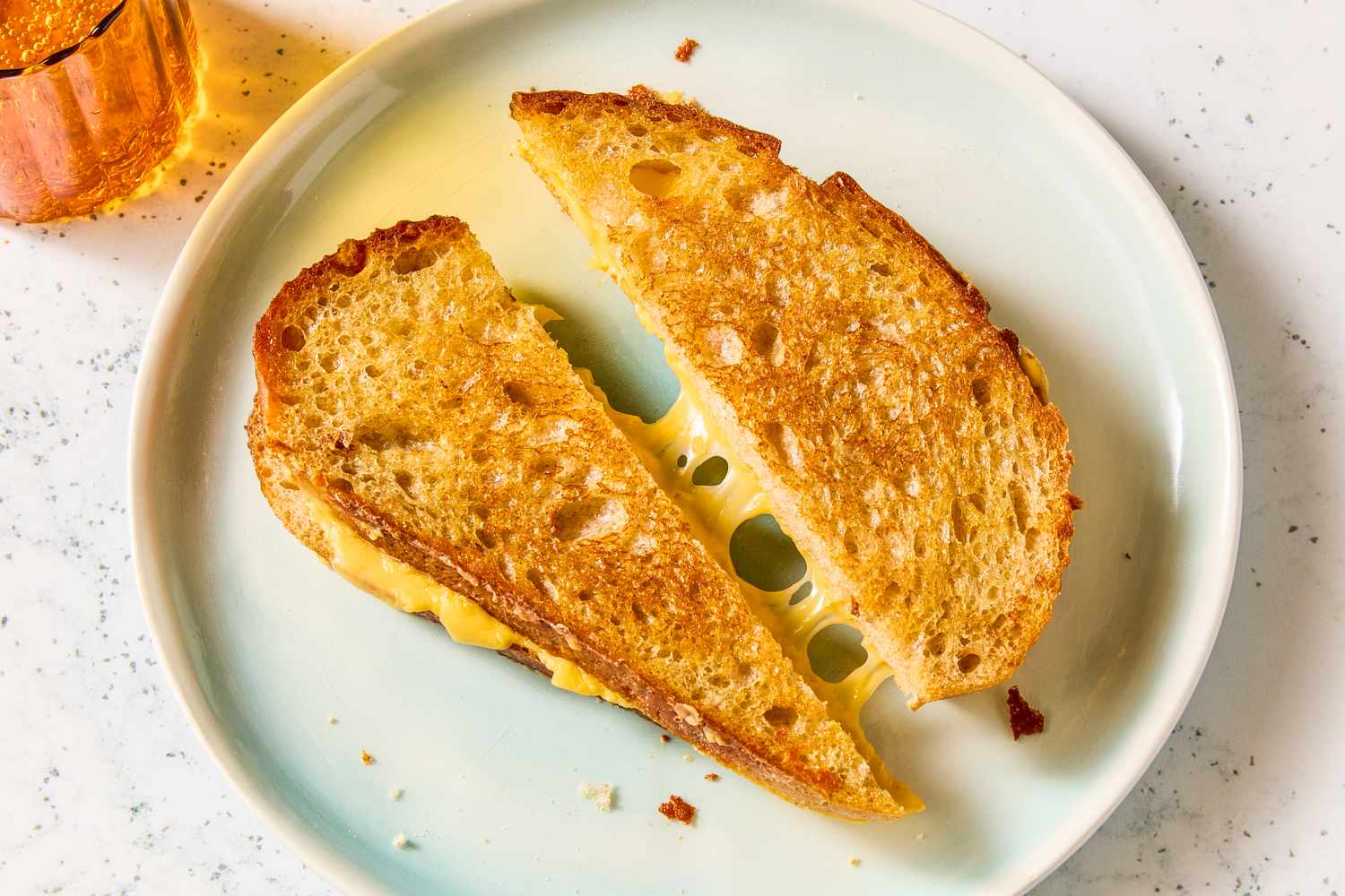 Two halves of a grilled cheese sandwich on a plate