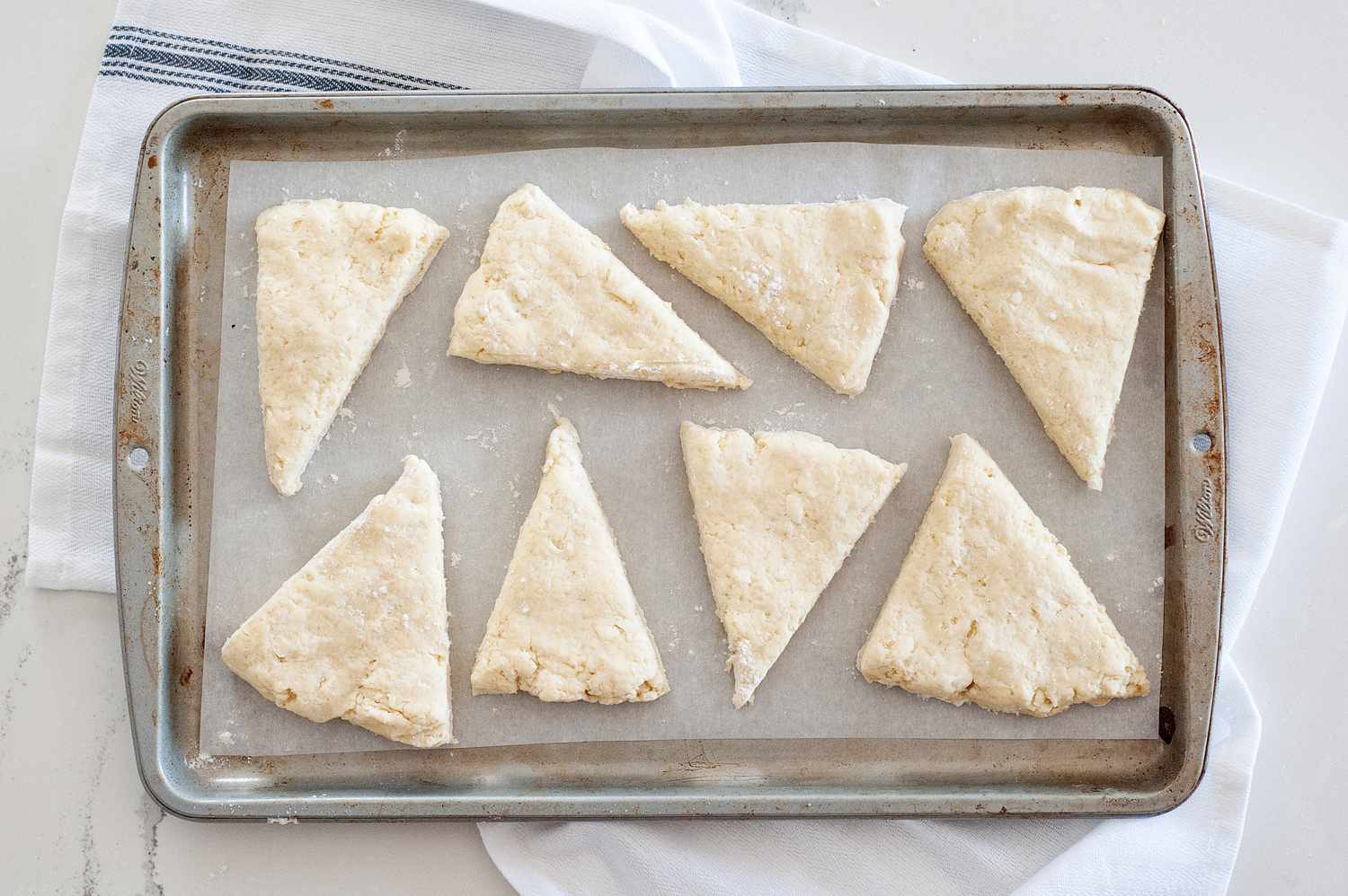 Basic Scone Recipe cut into triangles and ready to be baked on a baking sheet.