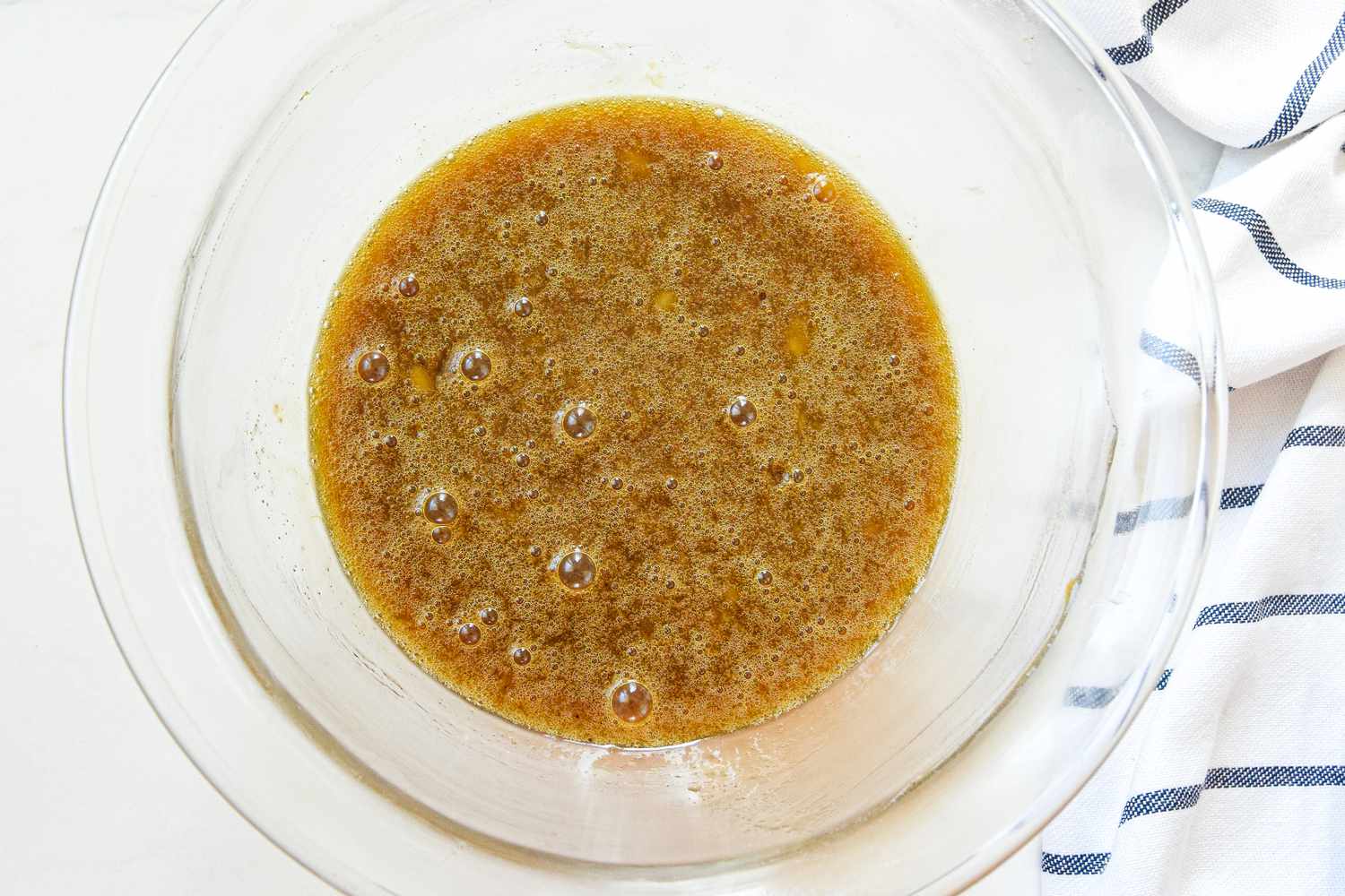 Egg and Vanilla Added to Bowl of Wet Ingredients for Oatmeal Cookies Recipe