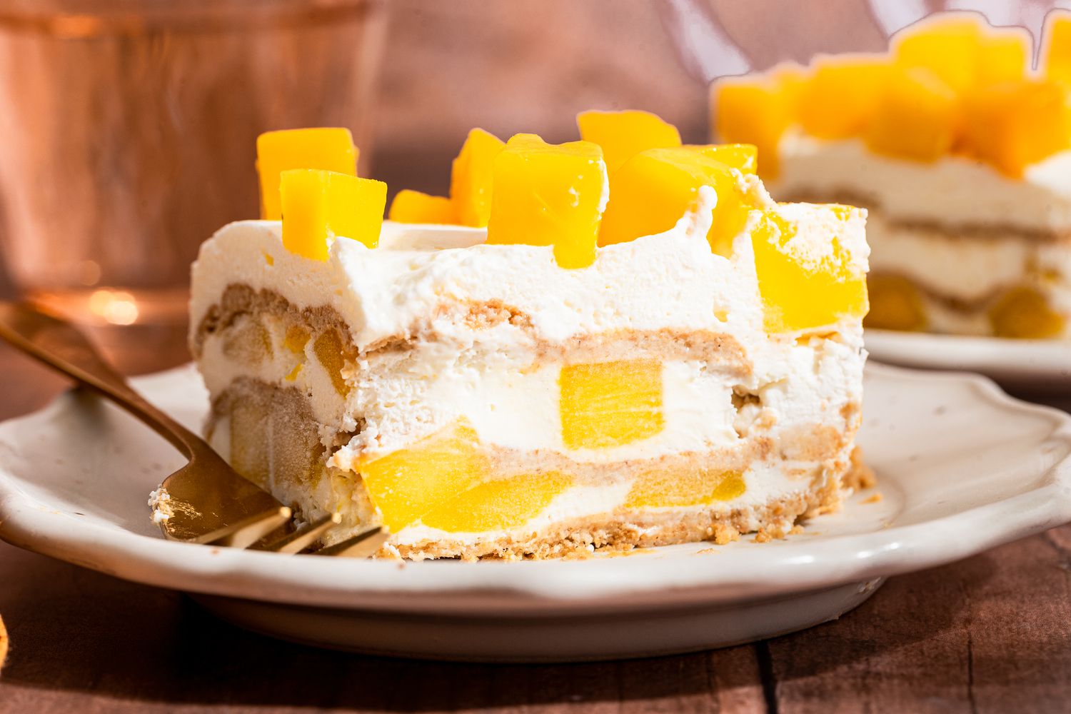 slice of mango float (mango royale) on a plate (close-up, cross-section cut facing forward)