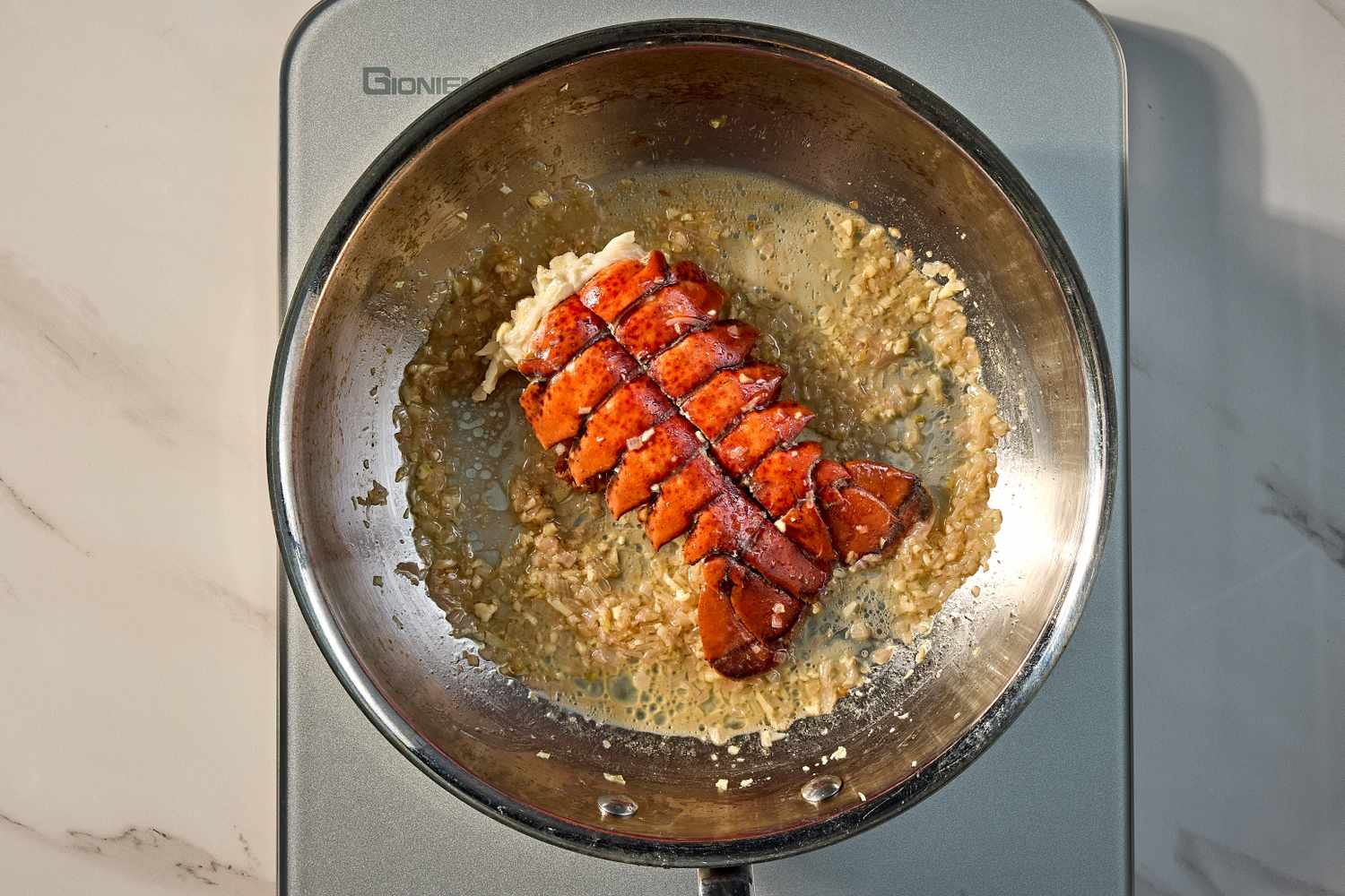 Overhead view of cooking the lobster in a pan for Baked Lobster Dip