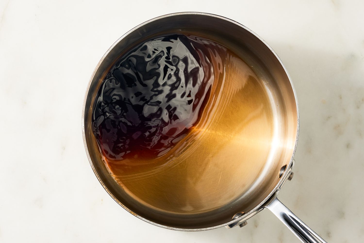 Overhead view of cola heating in a saucepan for Coca Cola Cake recipe