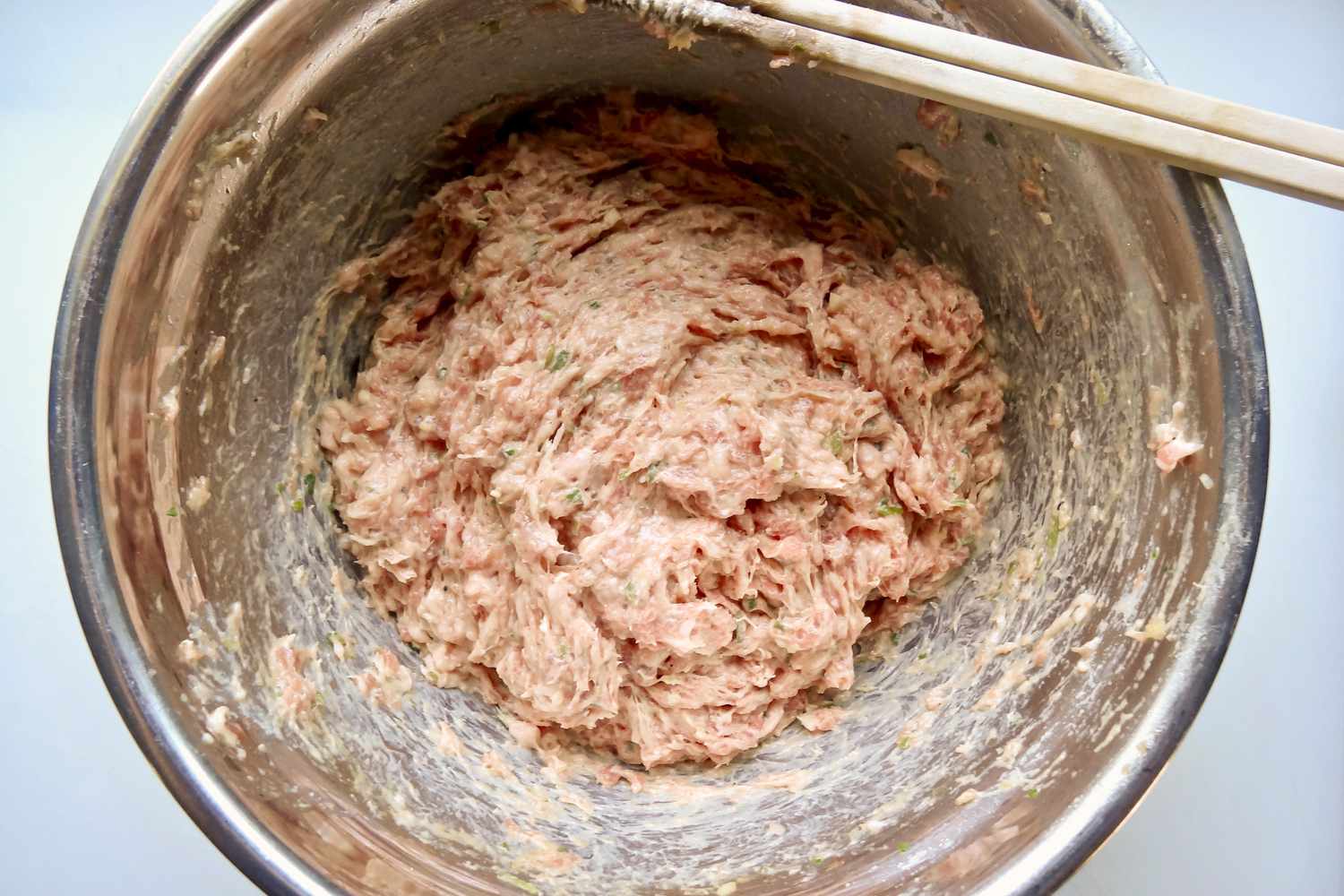 Pork filling mixed together with chopsticks for an easy wonton soup.