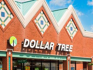 Exterior of a Dollar Tree store with a brick facade and decorative motifs on the roofline