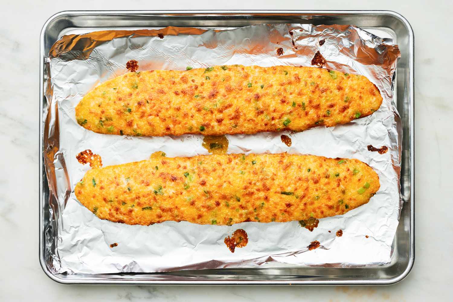 Baked Cheesy Bread on a Aluminum Foil Lined Baking Sheet 