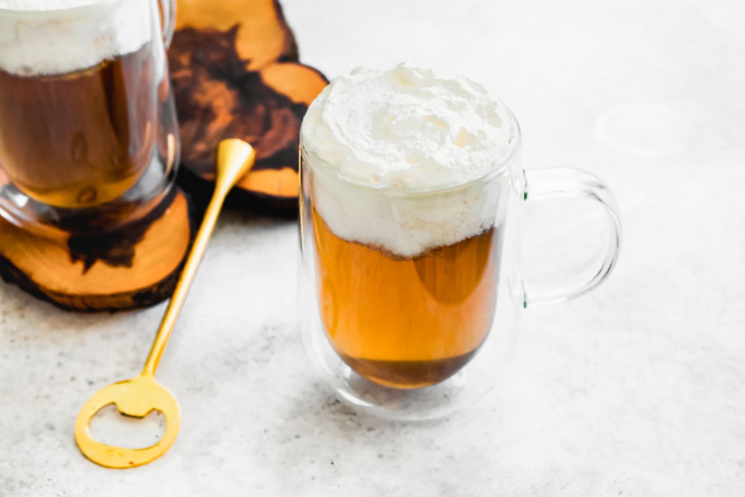 Butterbeer with Whipped Cream Next to Another Mug with More Butterbeer 