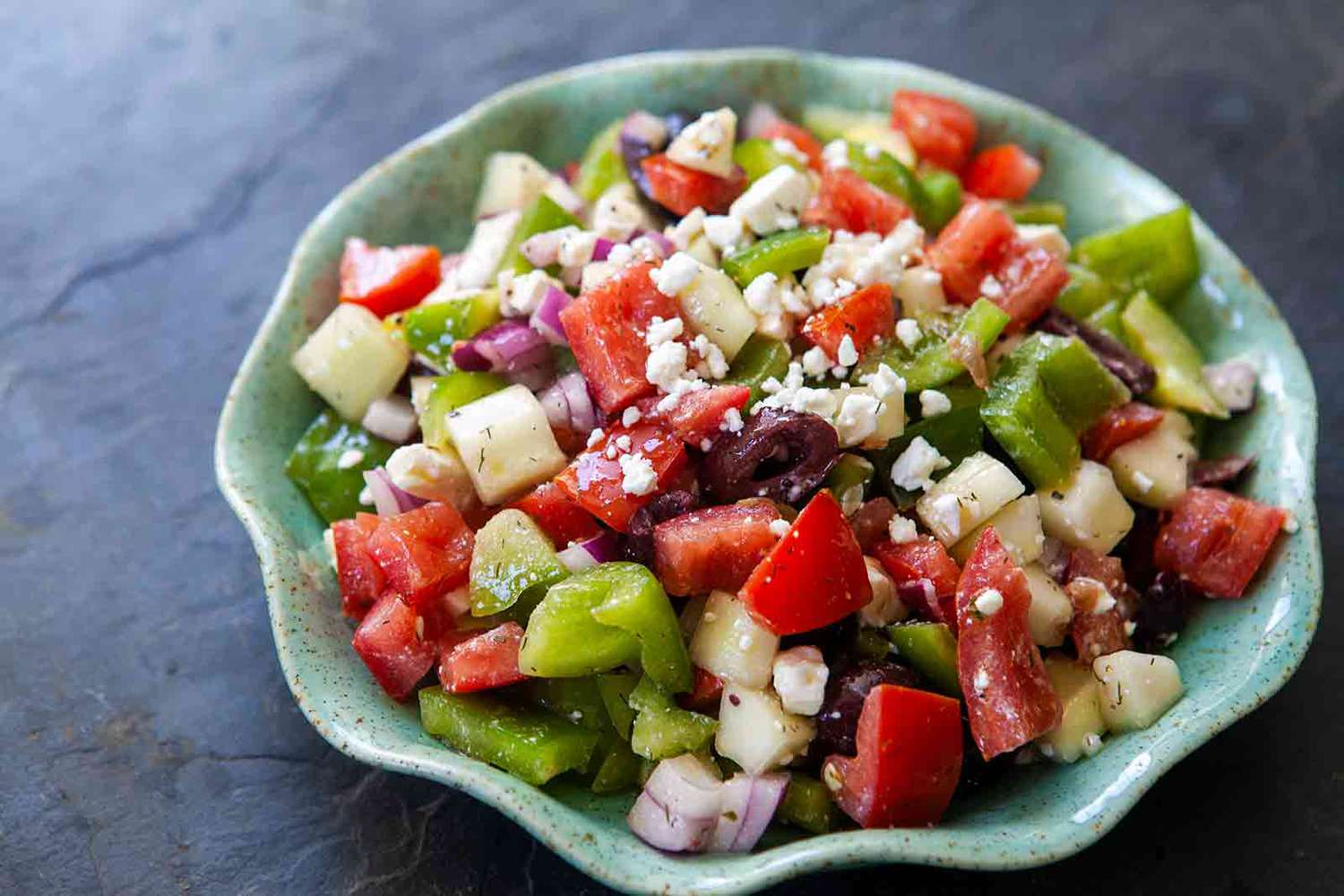 Easy Greek Salad tossed with greek salad dressing in a bowl