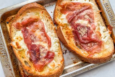 Overhead view of two pieces of 4-ingredient ham and cheese toast on a toaster oven tray