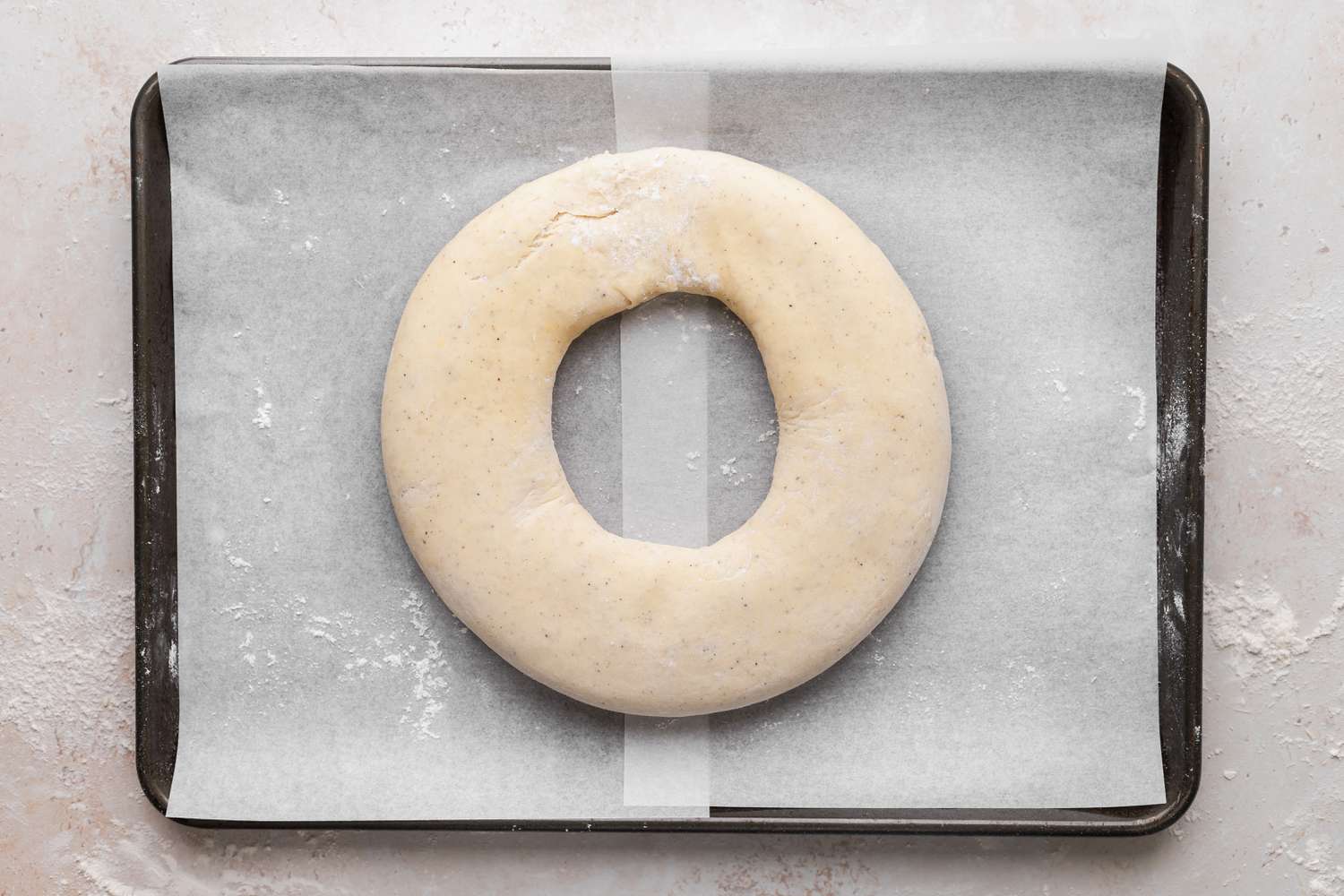 A ring shaped kringle on a parchment lined baking sheet.