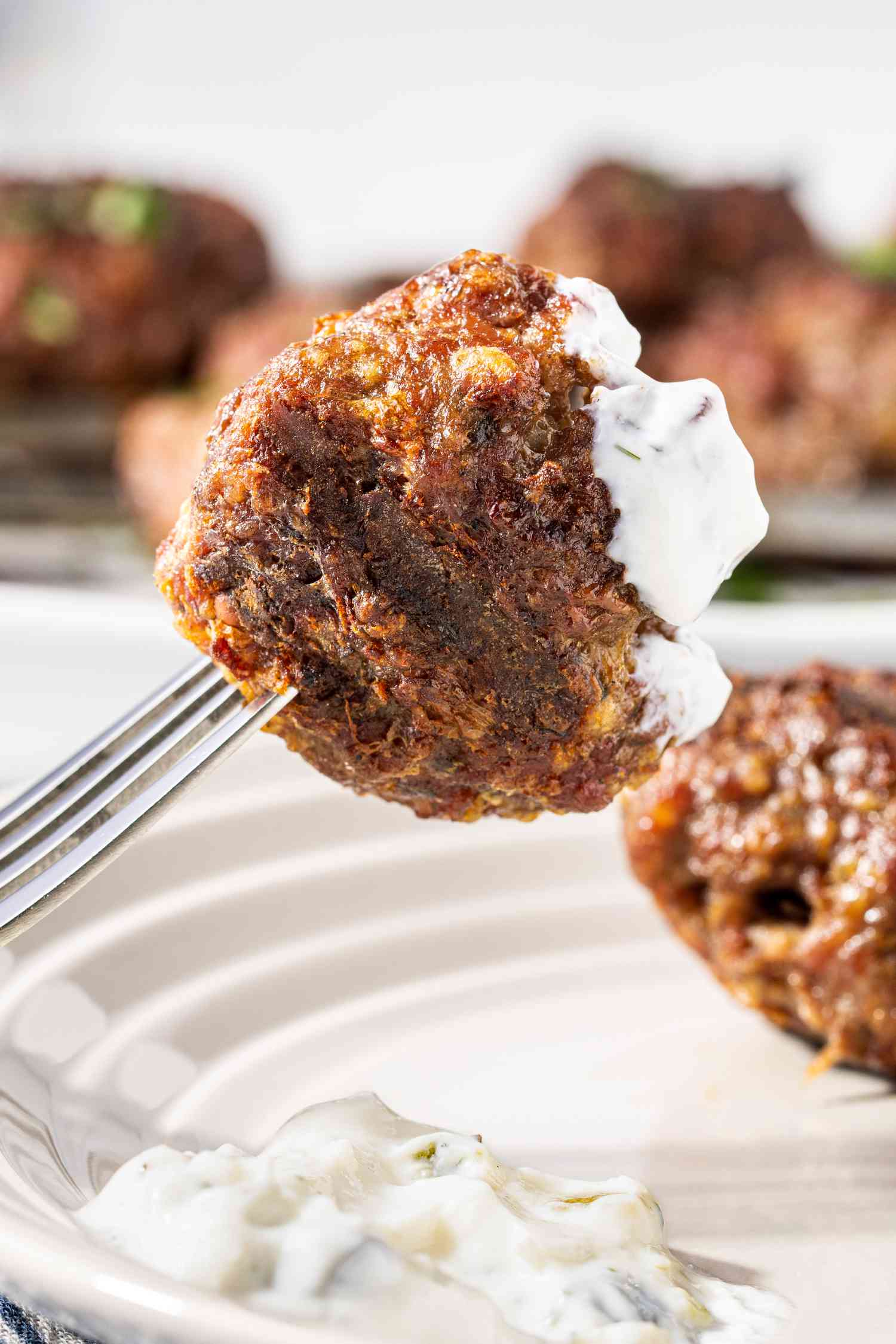 Fork With a Grilled Greek Meatball After Dipped in Tzatziki