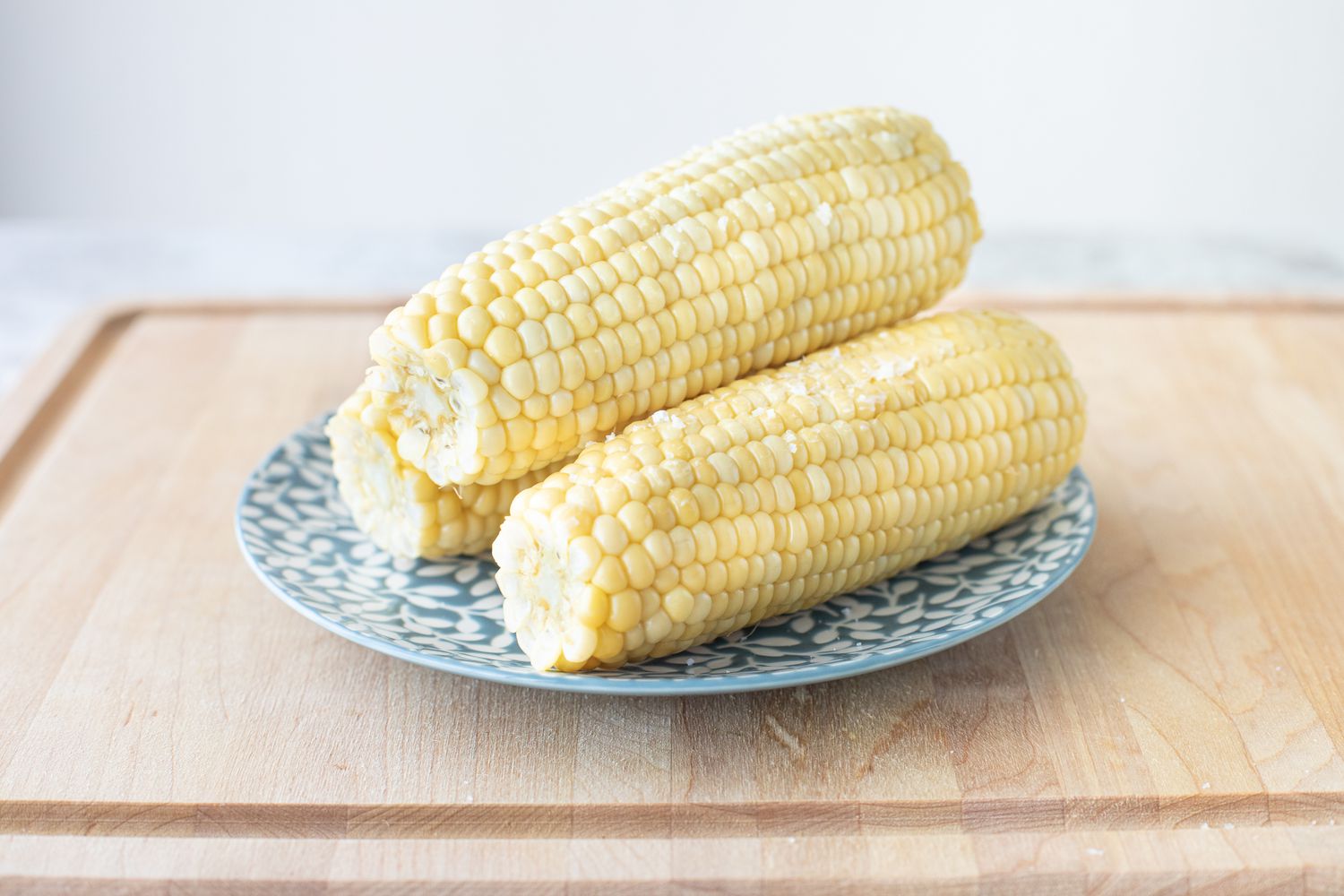 Three ears of corn on a blue plate