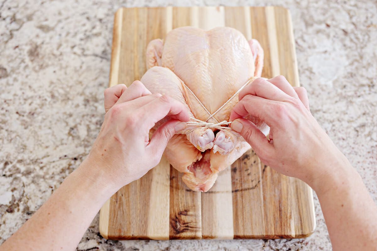 Truss a chicken with string tie a bow around the legs