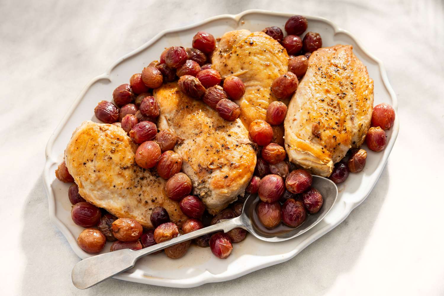 Plated Honey Balsamic Chicken with Grapes and a spoon