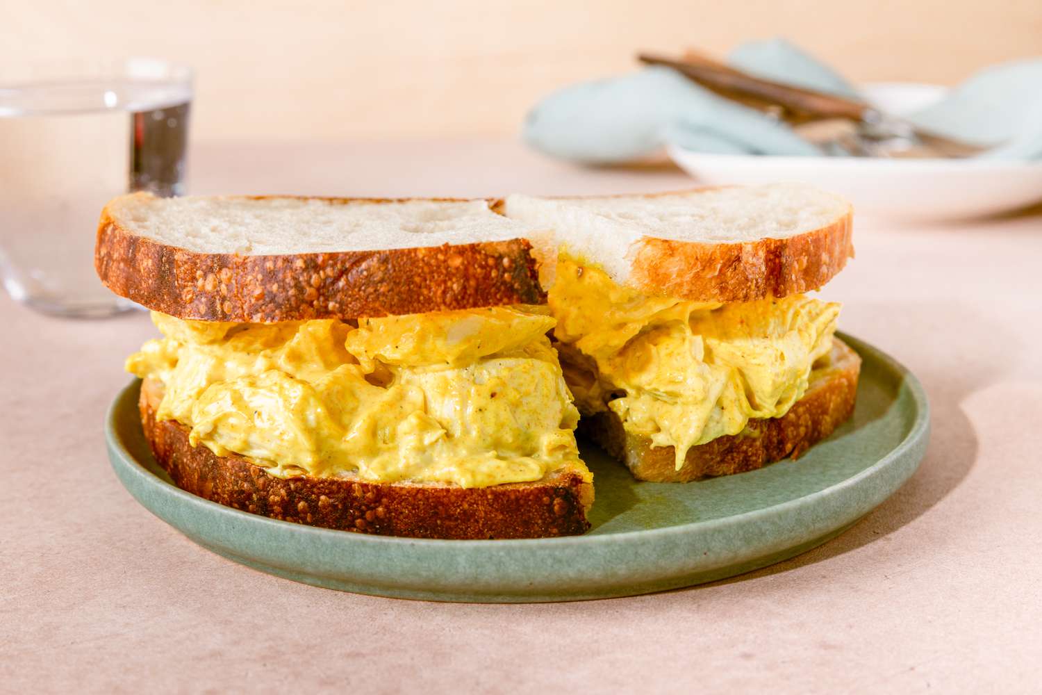 Curry chicken salad sandwich on a green plate