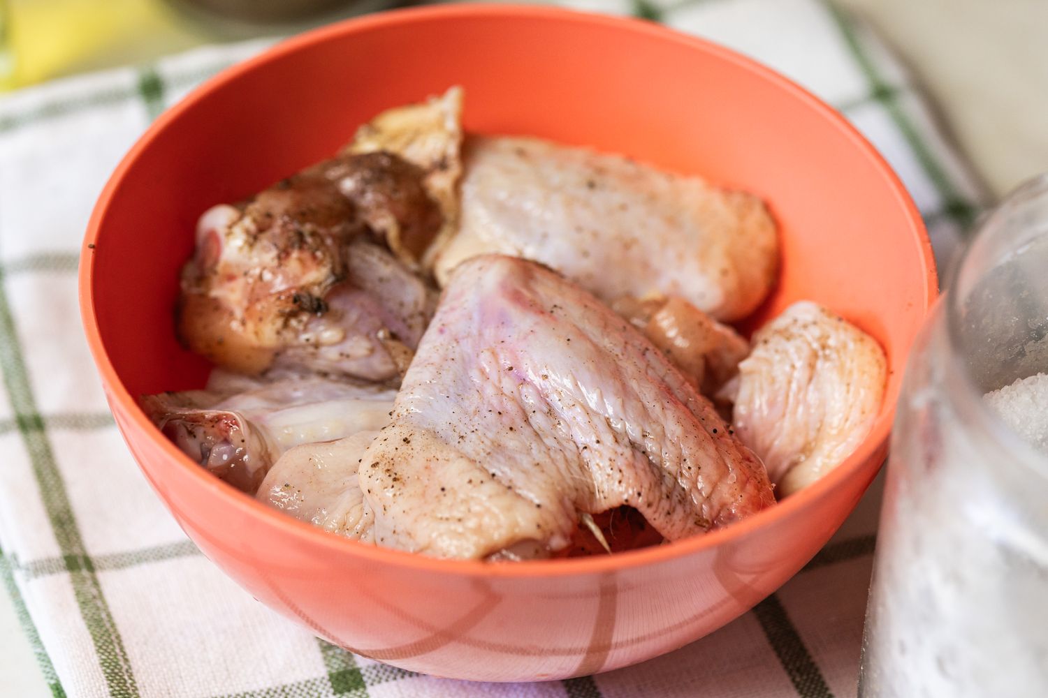 Raw chicken wings seasoned and in a bowl prepared for cooking or marination