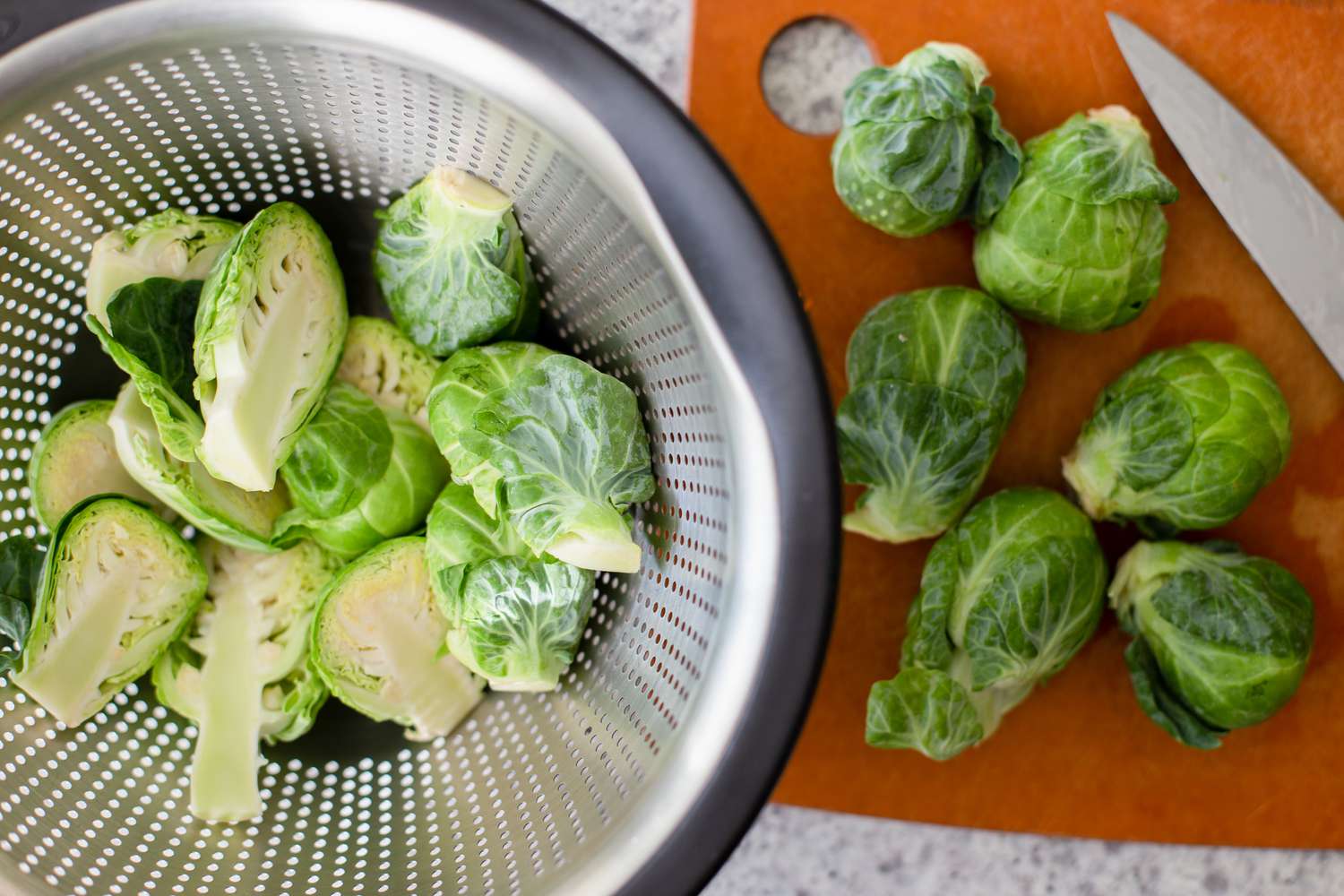 Washed Brussel Sprouts Cut in Half and Placed in a Colander for Deep Fried Brussel Sprouts