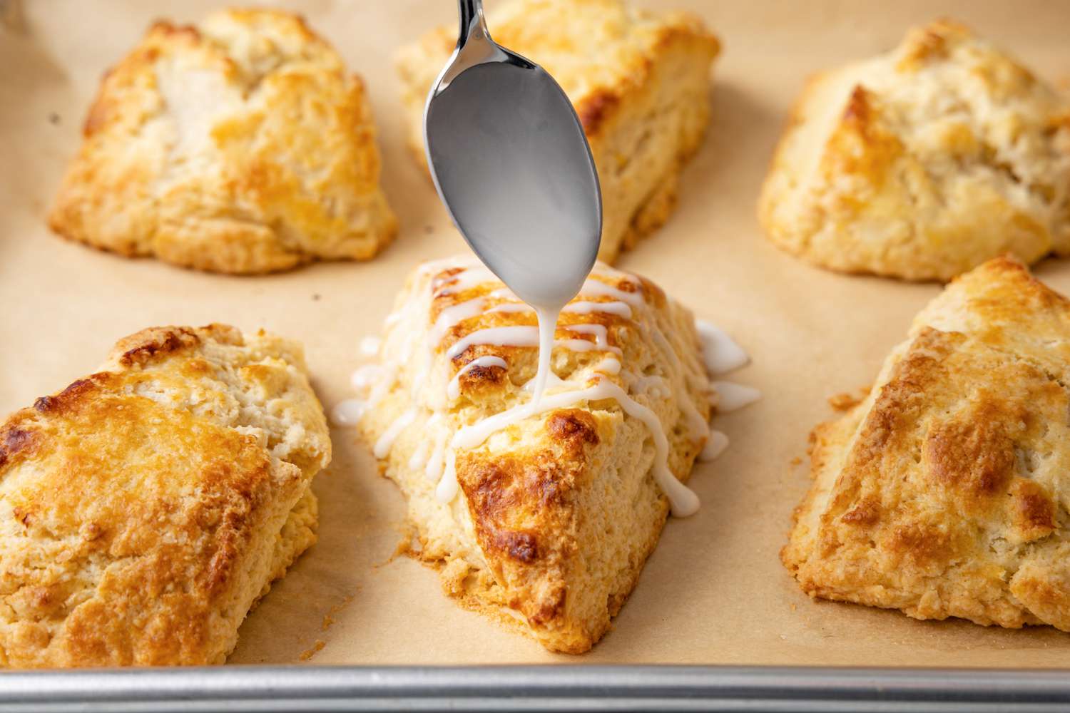Lemon Glaze Drizzled onto Lemon Scones Using a Spoon