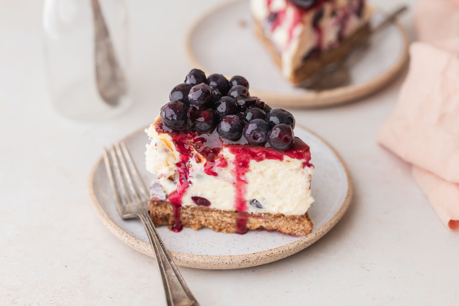 Slice of blueberry cheesecake on small plate.