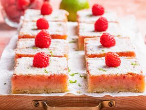raspberry lime rickey bars on a parchment covered tray (close-up)