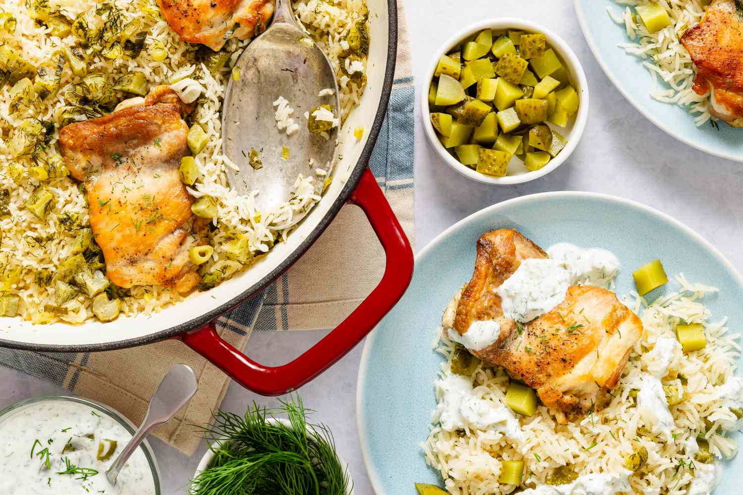 A skillet with chicken rice and chopped dill pickles served alongside plated portions and a bowl of extra pickles