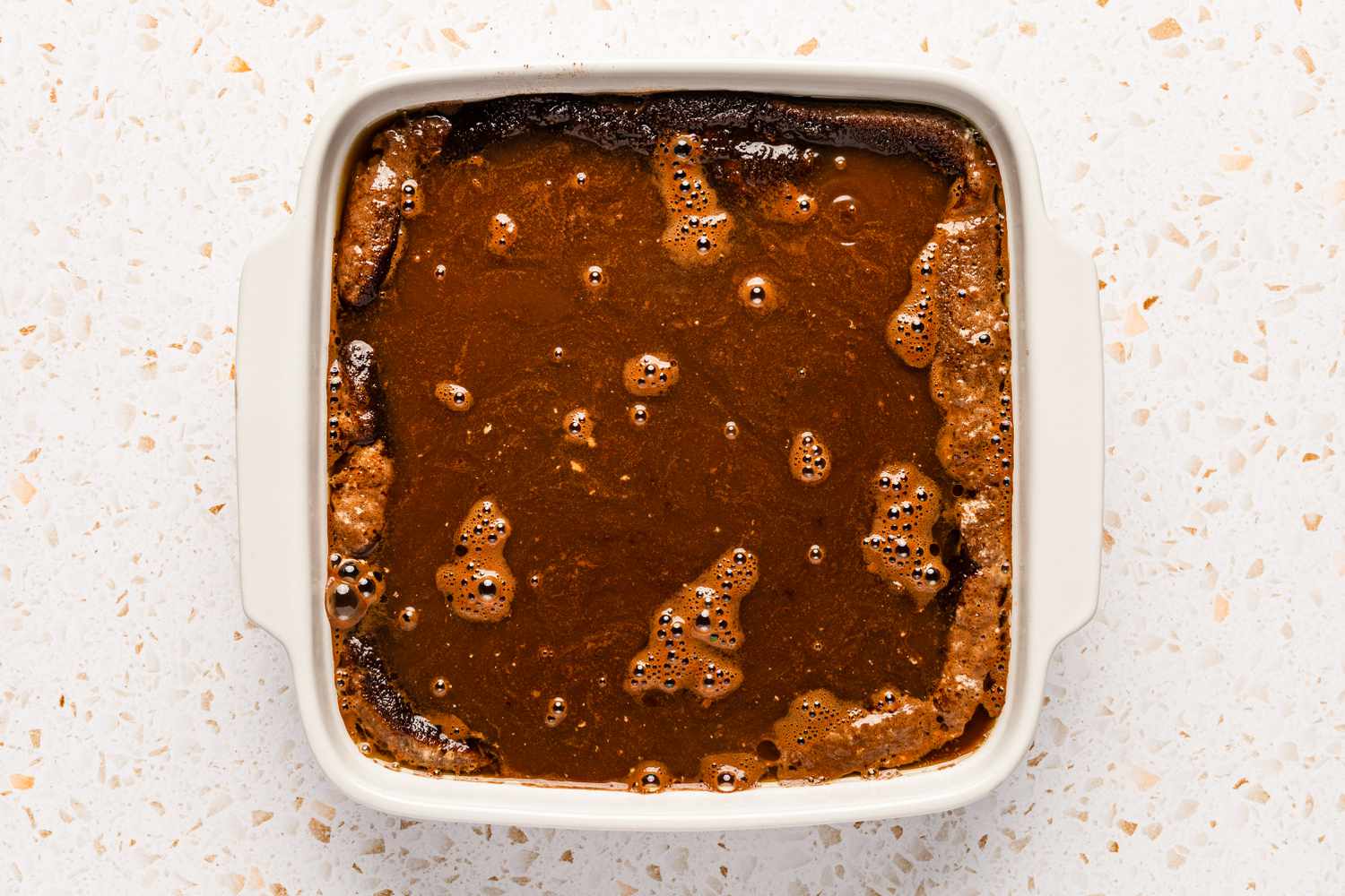 Hot water poured on top of the rest of the ingredients in a square baking dish for chocolate cobbler recipe