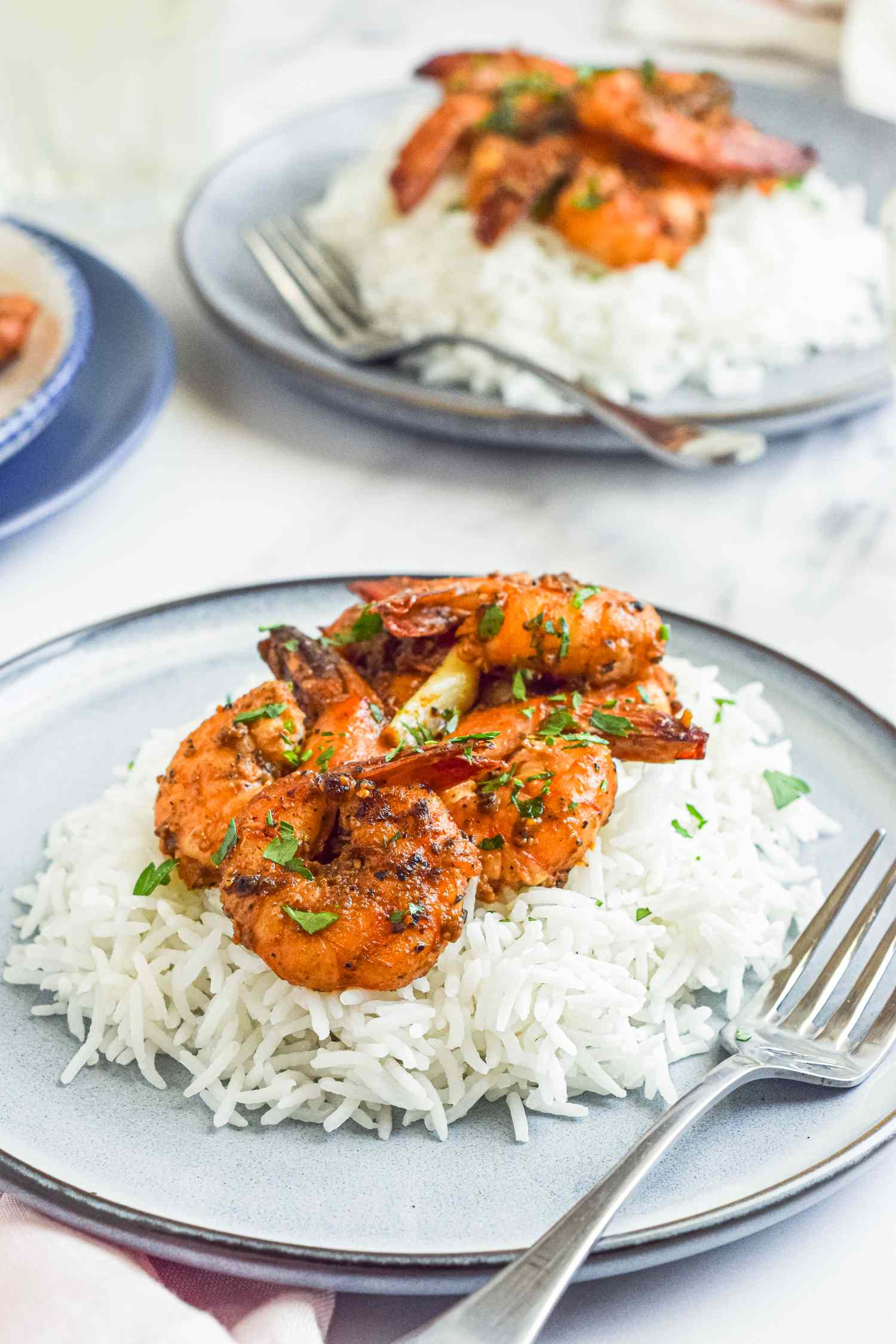 Plates of shrimp seasoned with garlic and pepper served on white rice