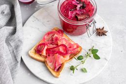 A platter of appetizers topped with pickled red onions and a container of red onions next to the appetizers on the platter.