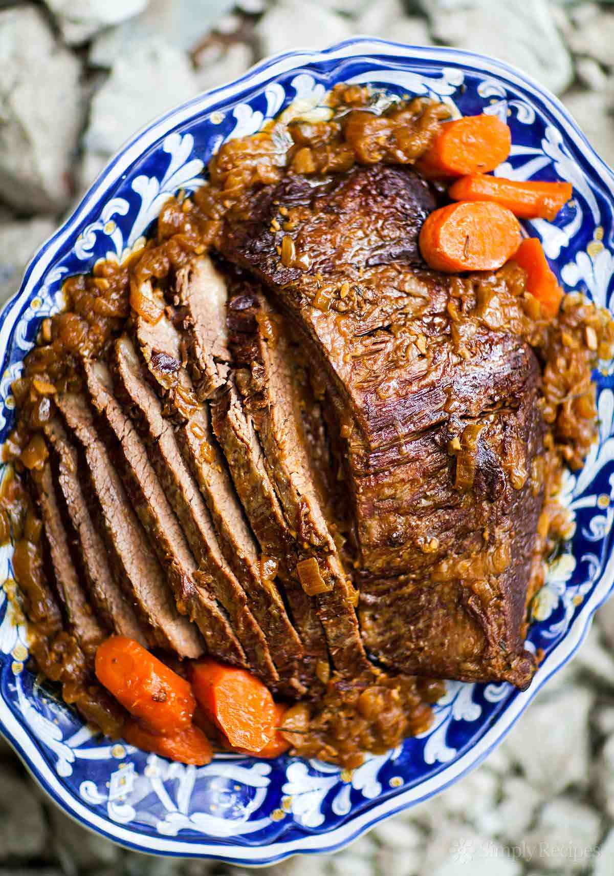 Pot Roast recipe on blue and white platter with carrots