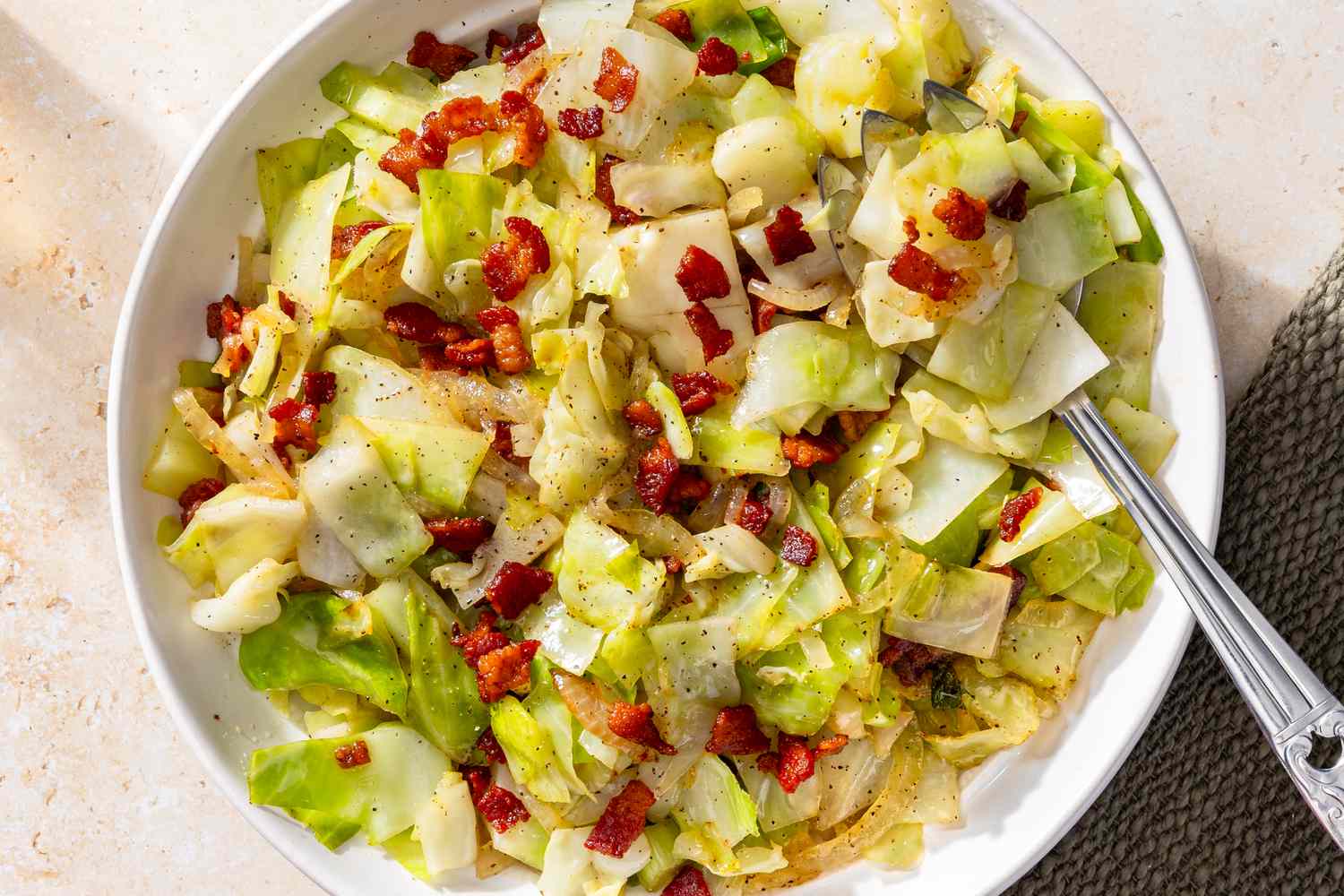 overhead view of a bowl of Southern “Fried” Cabbage with a serving spoon